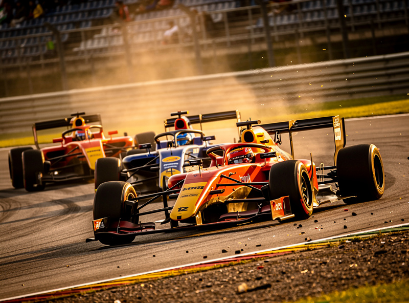 Formula 3 cars racing in a pack through a corner