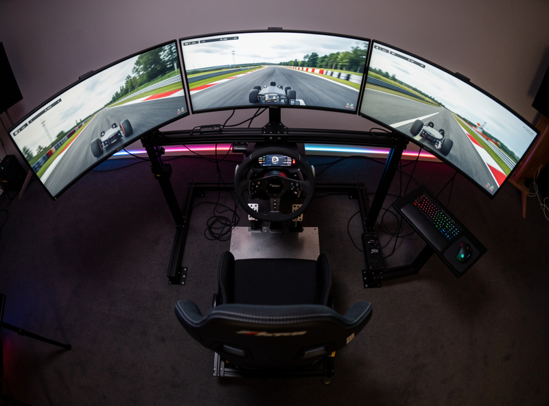 Wide angle view of triple monitor racing setup showing 180-degree field of view