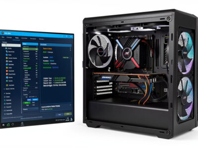 Performance tuning screen beside an open sim racing PC with a large air cooler