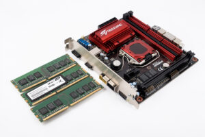 RAM modules and an NVMe SSD beside a motherboard for a sim racing PC build