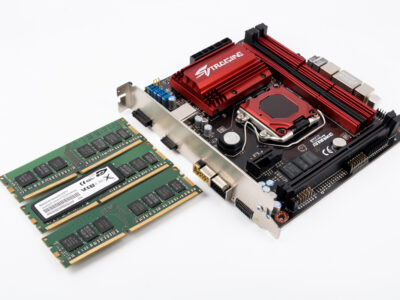 RAM modules and an NVMe SSD beside a motherboard for a sim racing PC build
