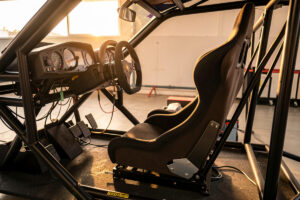 Reclining bucket racing seat mounted in a sim racing rig in GT driving position