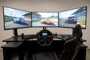 Triple monitors mounted on a sim racing rig with the side screens angled inward