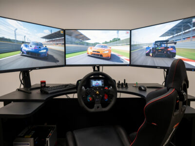 Triple monitors mounted on a sim racing rig with the side screens angled inward