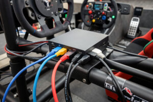 Powered USB hub mounted on a sim racing rig with peripheral cables plugged in