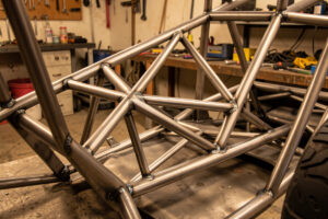 A welded steel sim-racing pedal deck cross-braced to the seat frame with triangulated tube