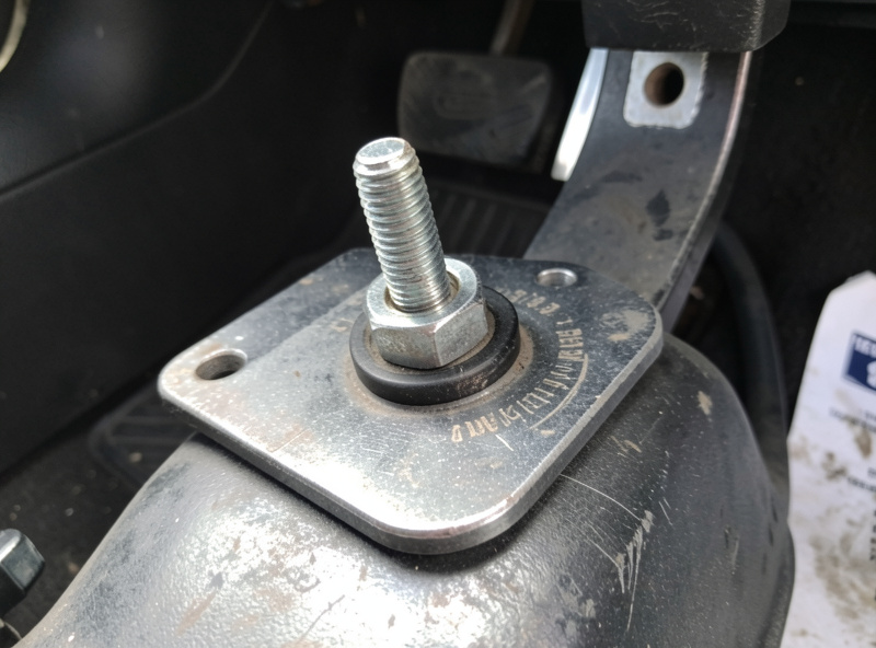 Load-cell brake pedal set bolted to a steel pedal plate with visible wear on the pedal faces