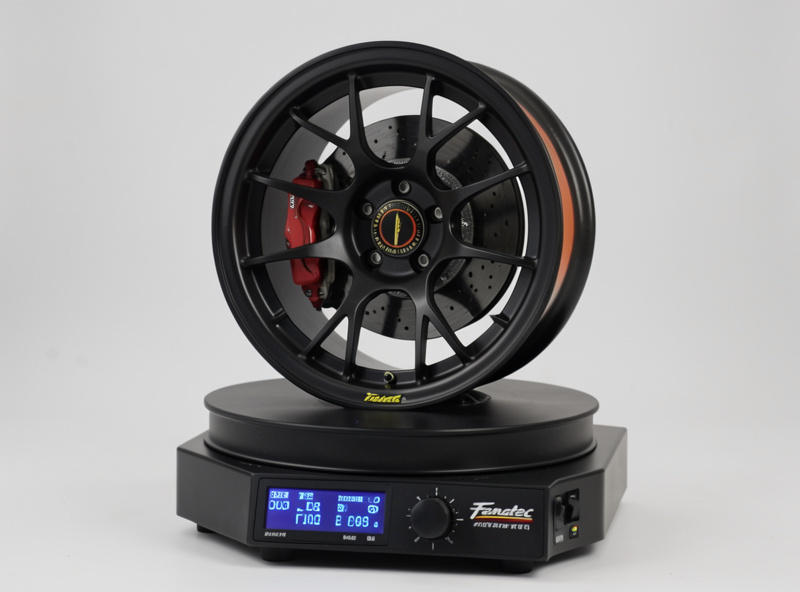 A Fanatec formula-style wheel rim mounted on a direct-drive base with the tuning menu visible on its OLED