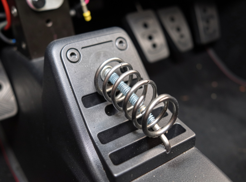 Close-up of a sim racing throttle pedal with an added spring for resistance